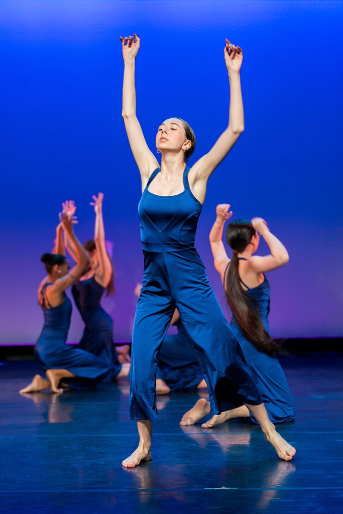 Steps Academy students in dance performance - 4 jazz dancers on stage in blue strapless jumpsuits